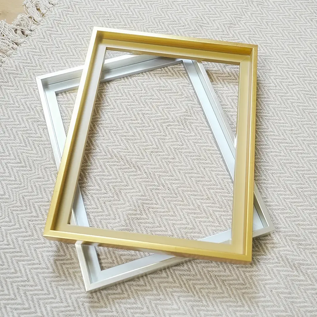 Zwei leere Aluminiumrahmen in Gold und Silber übereinander