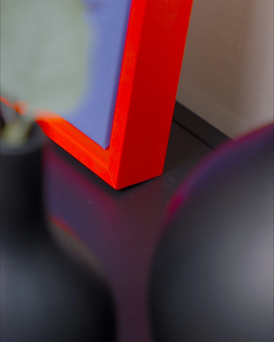 Detailaufnahme der Ecke des Schattenfugenrahmens Jill in leuchtendem Neon-Rot für Leinwandbilder in wohnlichem Ambiente