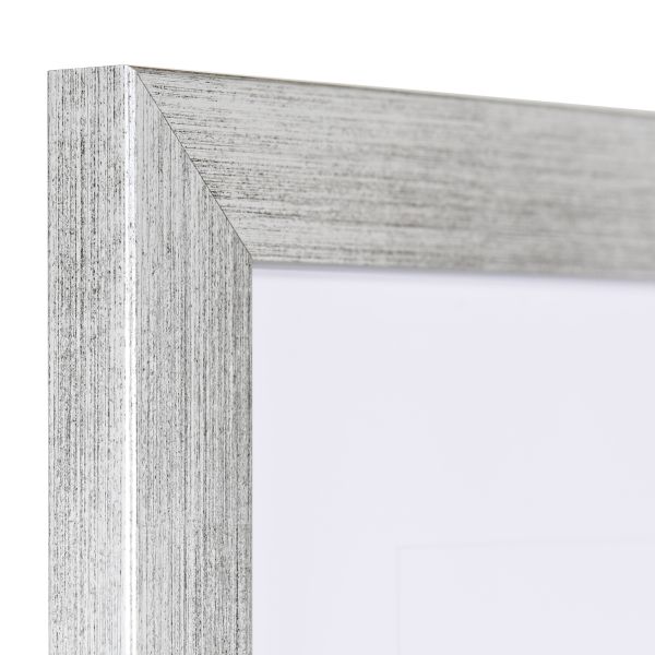 Ansicht der Ecke eines silbernen Bilderrahmens mit sichtbarer Holzstruktur, glatter Oberfläche und kantigem, schlichtem Profil