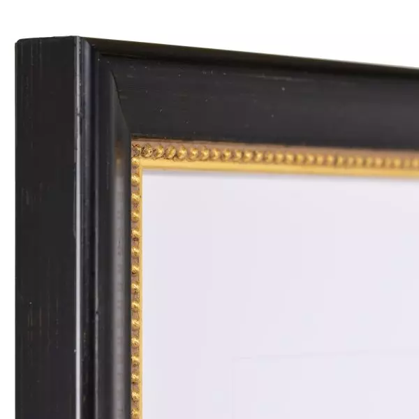 Ansicht der Ecke eines schwarzen Holzrahmens mit von Hand aufgebürsteten Schlagmetall und einem Perlstab an der Innenkante
