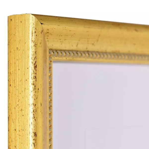 Ansicht der Ecke eines goldenen Holzrahmens mit von Hand aufgebürsteten Schlagmetall und einem Perlstab an der Innenkante